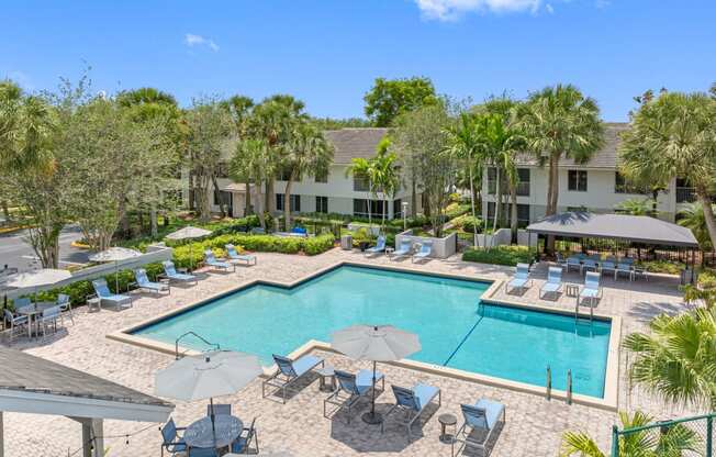 a swimming pool with chairs and umbrellas at the resort