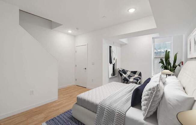 A bedroom with a bed, pillows, and a plant.