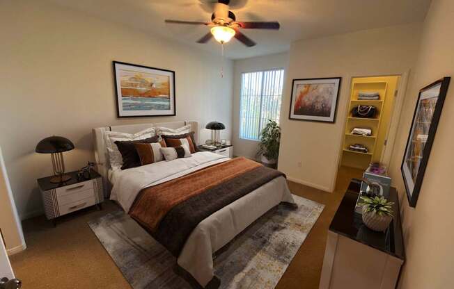 A bedroom with a bed, nightstands, and a ceiling fan.