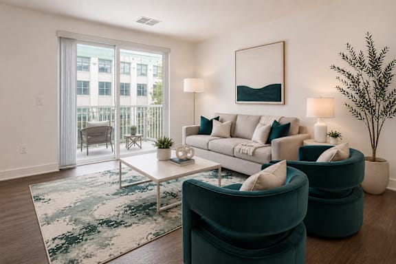 A living room with a white couch, a rug, and a potted plant.