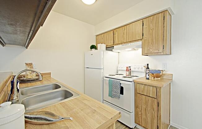 a kitchen with a white refrigerator freezer next to a white stove top oven