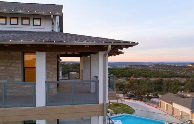 a balcony with a view of a house and a pool