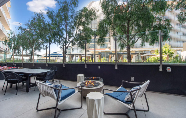 an outdoor patio with tables and chairs and a fire pit