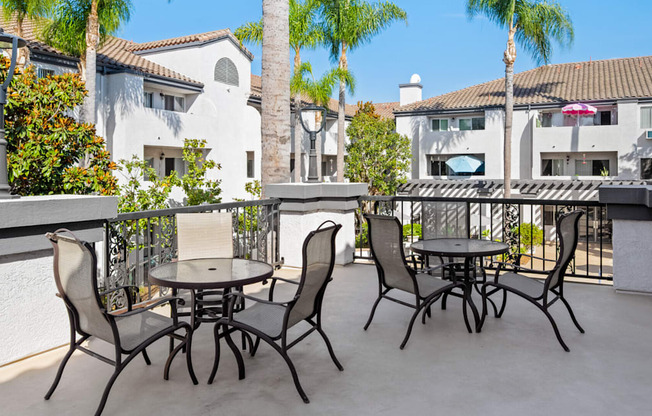 a patio with tables and chairs on a balcony