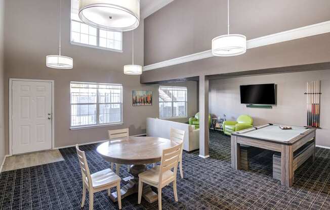 A room with a pool table and a television.