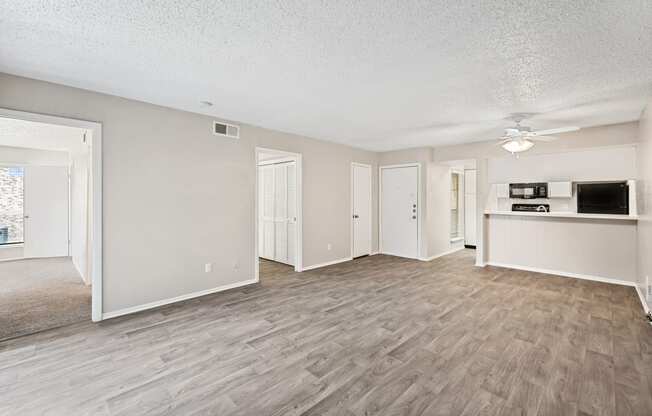 an open living room and kitchen with a ceiling fan