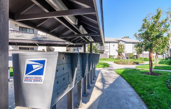 A United States Postal Service mailbox is on a metal pole.