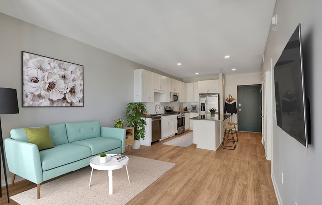 a living room with a couch a table and a kitchen in the background