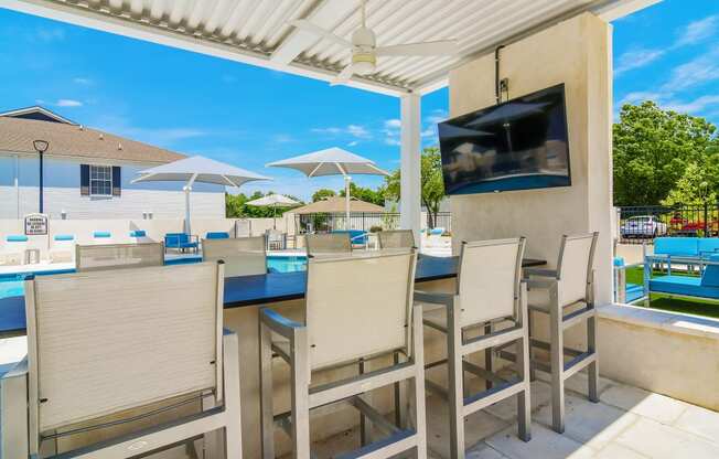 the backyard has a large patio with tables and chairs and a tv