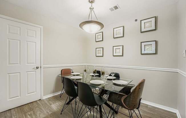 A dining room with a glass table and chairs.