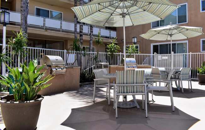 View of community grilling area with counters to prep food, seating under umbrellas