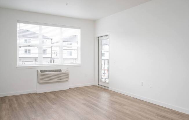 A room with a window showing a view of houses outside.