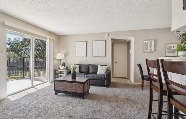 A living room with a grey couch, a coffee table, and a chair.