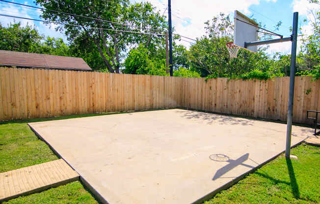 a basketball court in the backyard of a house