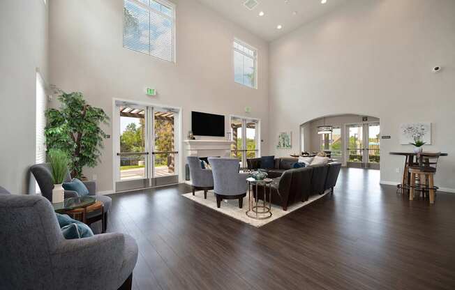 A living room with a grey couch and a wooden floor.