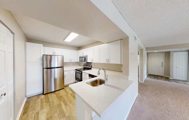 a kitchen with white cabinets and stainless steel appliances