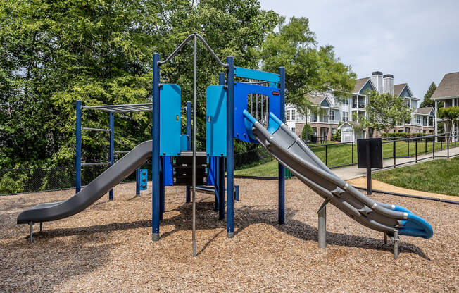 a playground with two slides and a climbing structure