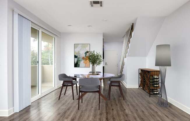 a dining room with a table and chairs and sliding glass doors