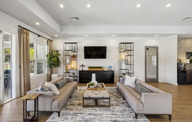 Lounge space in the leasing office with two couches and a television at Evergreen at Southwood in Tallahassee, FL