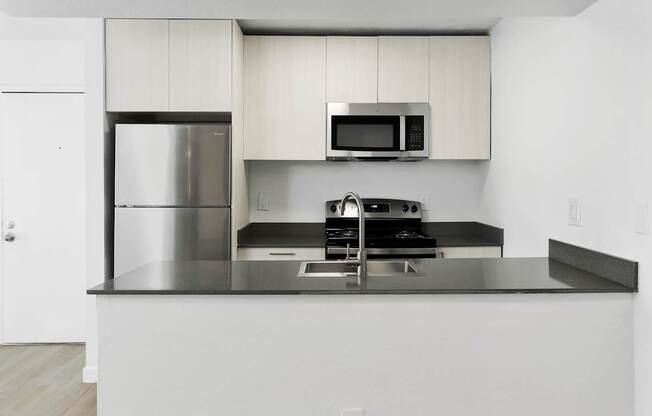 A modern kitchen with stainless steel appliances and white cabinets.