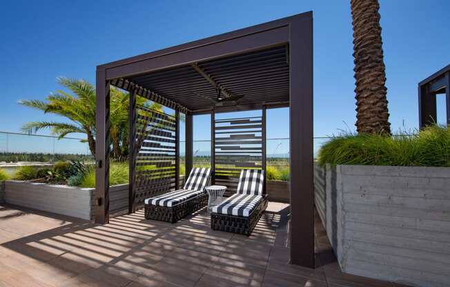 a covered patio with lounge chairs and a pergola