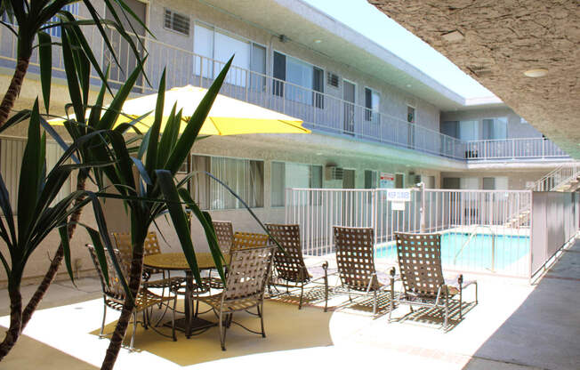 a patio with tables and chairs and a pool