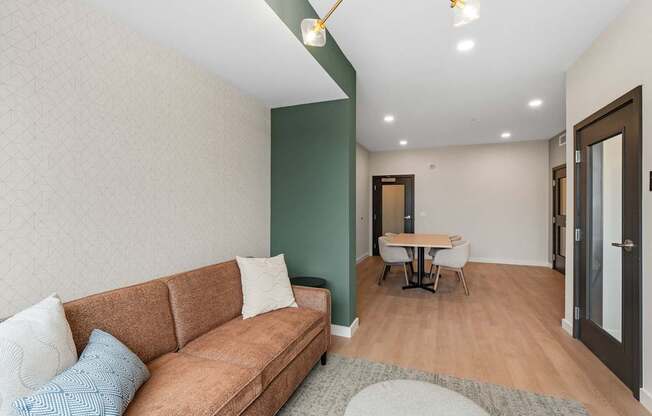 A living room with a brown couch and a small table.