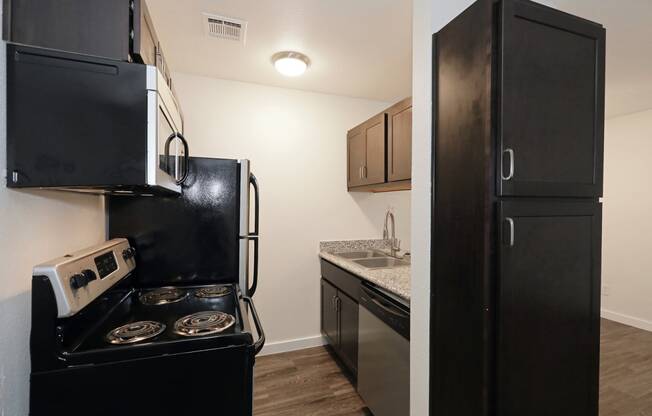 a kitchen with black cabinets and stainless steel appliances at Bennett Ridge Apartments, Oklahoma City, OK, 73132