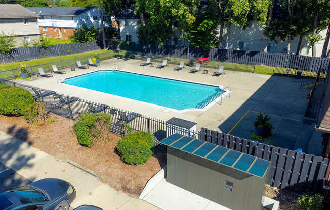 A small pool surrounded by a fence and a small building.