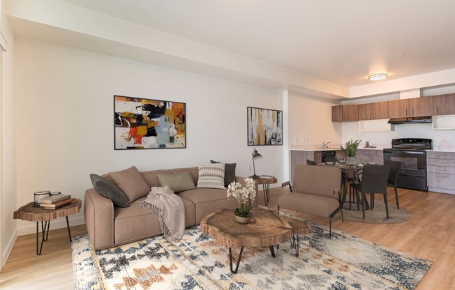 a living room with two couches and a coffee table in front of a kitchen with a at Jefferson Yards, Tacoma, WA 98402