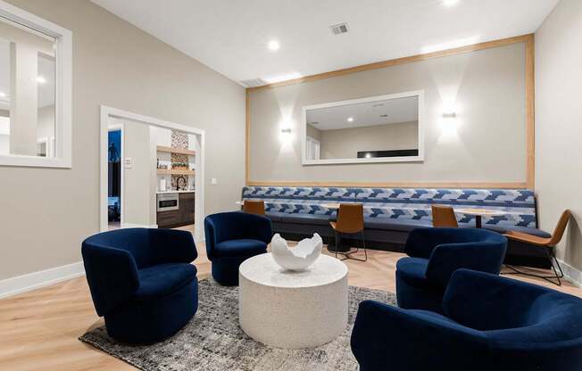 A living room with blue chairs and a white coffee table.