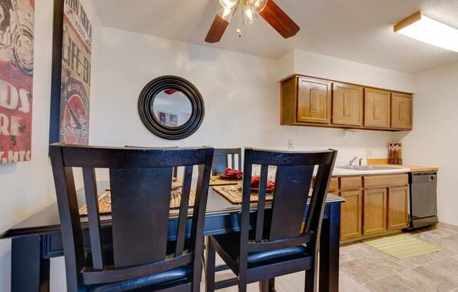 Dining area in the one-bedroom model unit at Olde English Village, with the kitchen visible in the background.