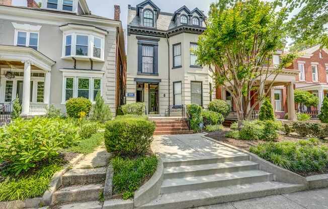 A row of houses with a tree in front of the middle house.