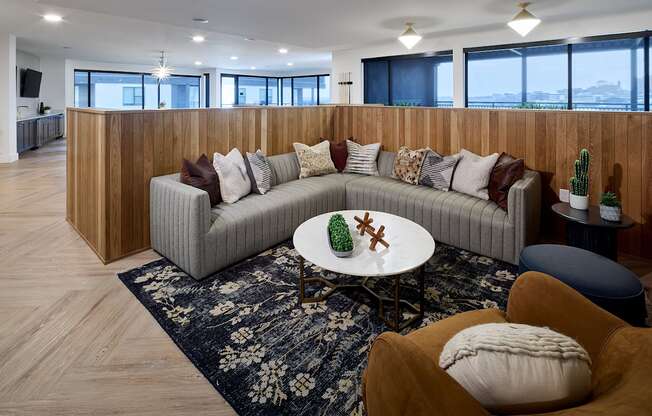 A modern living room with a grey sofa and a round table.