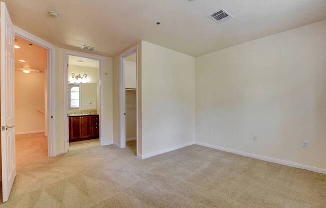 A room with a carpeted floor and a doorway leading to another room.