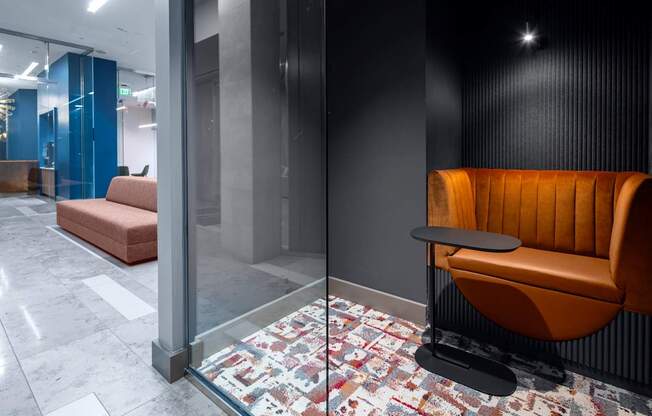 A modern office lobby with a glass wall and a patterned carpet.