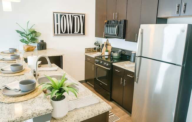 A kitchen with a Howdy sign on the wall.