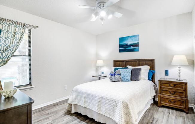 Apartment bedroom with overhead ceiling fan and hardwood flooring