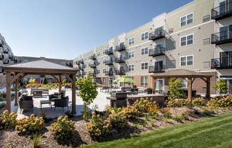A sunny day at a residential complex with a gazebo and landscaped gardens.