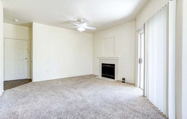 A living room with a fireplace and a carpet.