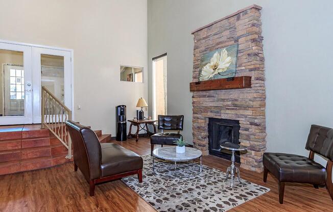 A living room with a stone fireplace and a painting of a white flower above it.