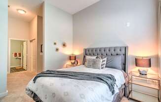 A bedroom with a large bed and a nightstand with a lamp at Highland Row Apartments, Memphis, TN, 38111