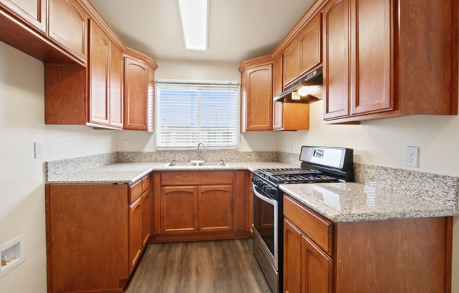 a kitchen with wood cabinets and granite countertops