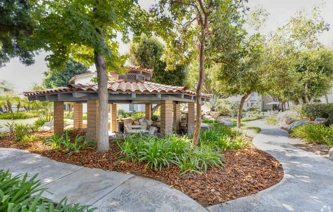 a stone gazebo sits in the middle of a garden