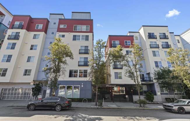 an apartment building on a city street with a car parked in front of it at Promenade at the Park Apartment Homes, Seattle, WA