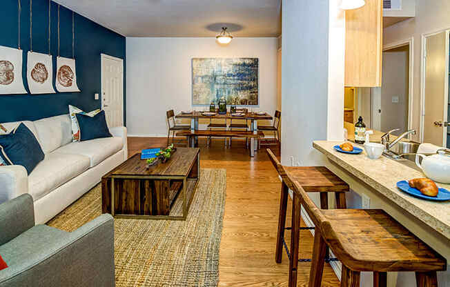 a living room and dining room with blue walls and wood floors at Villa Espada Apartments, San Antonio, TX, 78221