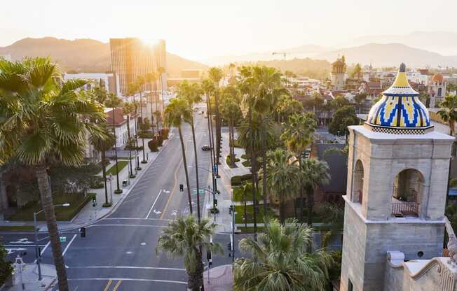 a view of a city street with palm trees and a building with a blue and at North Grove, Riverside, CA  