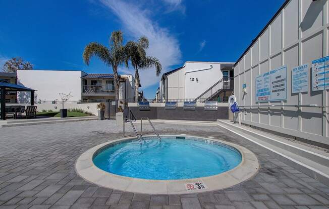 a hot tub sits in the middle of a patio next to a building
