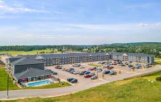 a large building with a pool and parking lot