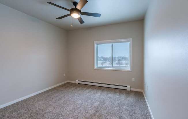 an empty room with a ceiling fan and a window. Fargo, ND Prairiewood Meadows | LivingFargo, ND Prairiewood Meadows